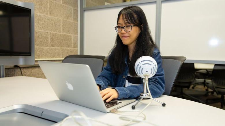 Anna Nguyen at Penn State Brandywine in front of a laptop. 