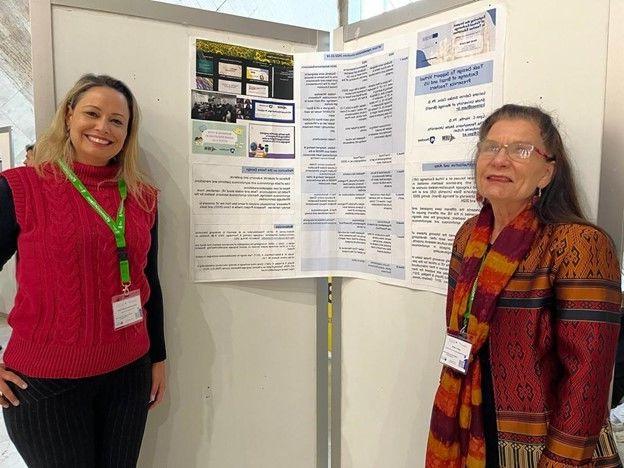 Two women giving a poster presentation